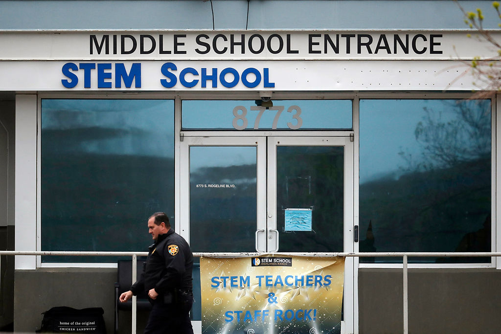 In this May 8, 2019, file photo, a Douglas County, Colorado, Sheriff's Department deputy walks past the doors to the STEM School Highlands Ranch